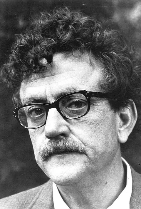 Photographie en noir et blanc : Kurt Vonnegut, cheveux bouclés, lunettes et moustache.